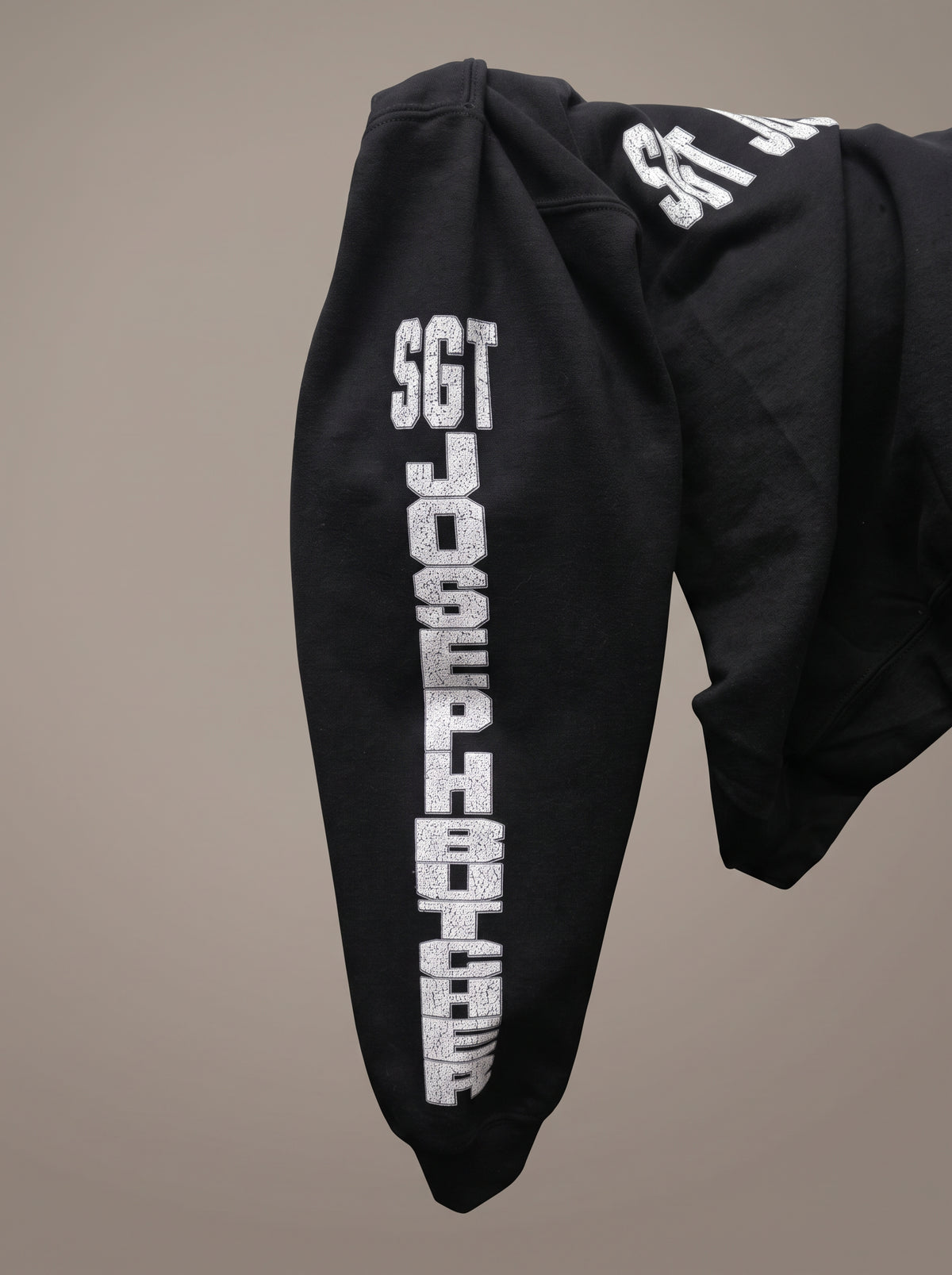 Team Butcher sleeve artwork detail photographed on the matching hoodie; crewneck uses the same sleeve graphic